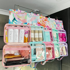 Hanging Toiletry Bags hanging side by side in shower on glass with their hooks by Mindful Marlo in designs Romy, Fleur Ivy, Haven and Willow