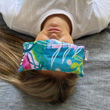Our Aria Eye Pillow being used by someone laying down with it on their eyes.